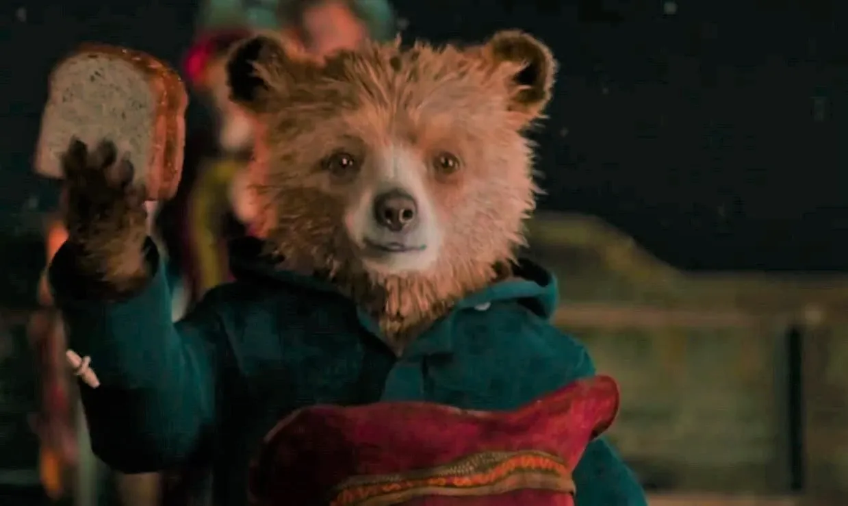 Paddington holds up a marmalade sandwich.